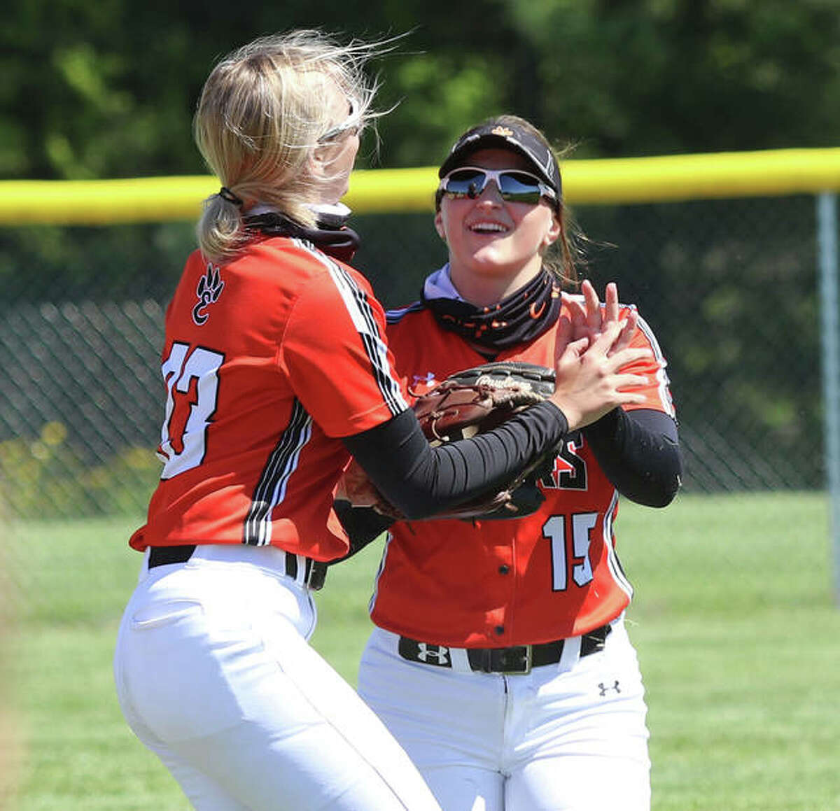 Edwardsville right fielder Sydney Lawrence (left) is greeted by second baseman Lexi Gorniak after Lawrence turned a diving catch into an inning-ending double play Wednesday in Piasa.