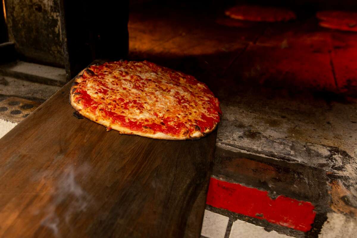 Hot pizza being pulled out of the oven at Sally's Apizza in New Haven on April 23, 2021.