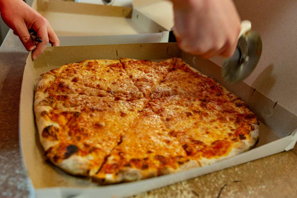 Hot pizza being cut at Zuppardi's Apizza in West Haven on April 23, 2021.