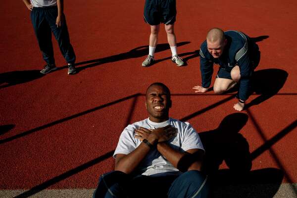 Airman Basic Robert Harris finishes his situp requirements for the final PT test at Joint Base San Antonio-Lackland while his wingman Ian Peskar keeps count.