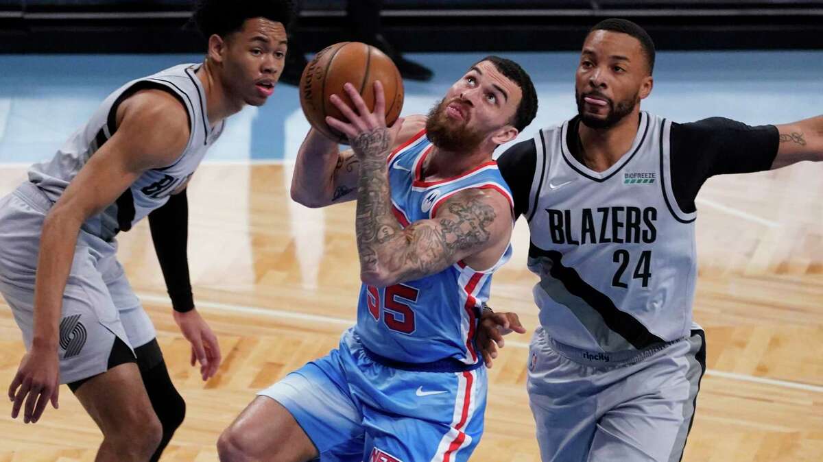 Brooklyn Nets guard Mike James (55) drives to the basket against Portland Trail Blazers forward Norman Powell (24) and guard Anfernee Simons during the first half of an NBA basketball game, Friday, April 30, 2021, in New York. (AP Photo/Mary Altaffer)