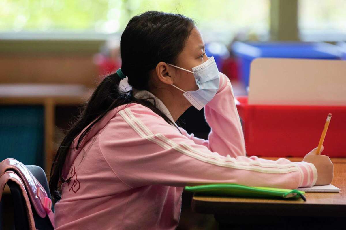 Fourth grade students wear masks while working on schoolwork at Garfield Elementary School in Oakland, Calif. Monday, April 19, 2021 during the first day of partial school-wide, in-person learning.