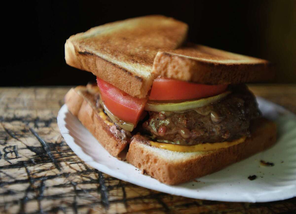 The world's first hamburger, on toast with cheese, tomato, and onion, at the landmark Louis Lunch in New Haven, Conn. on Thursday, May 13, 2021.