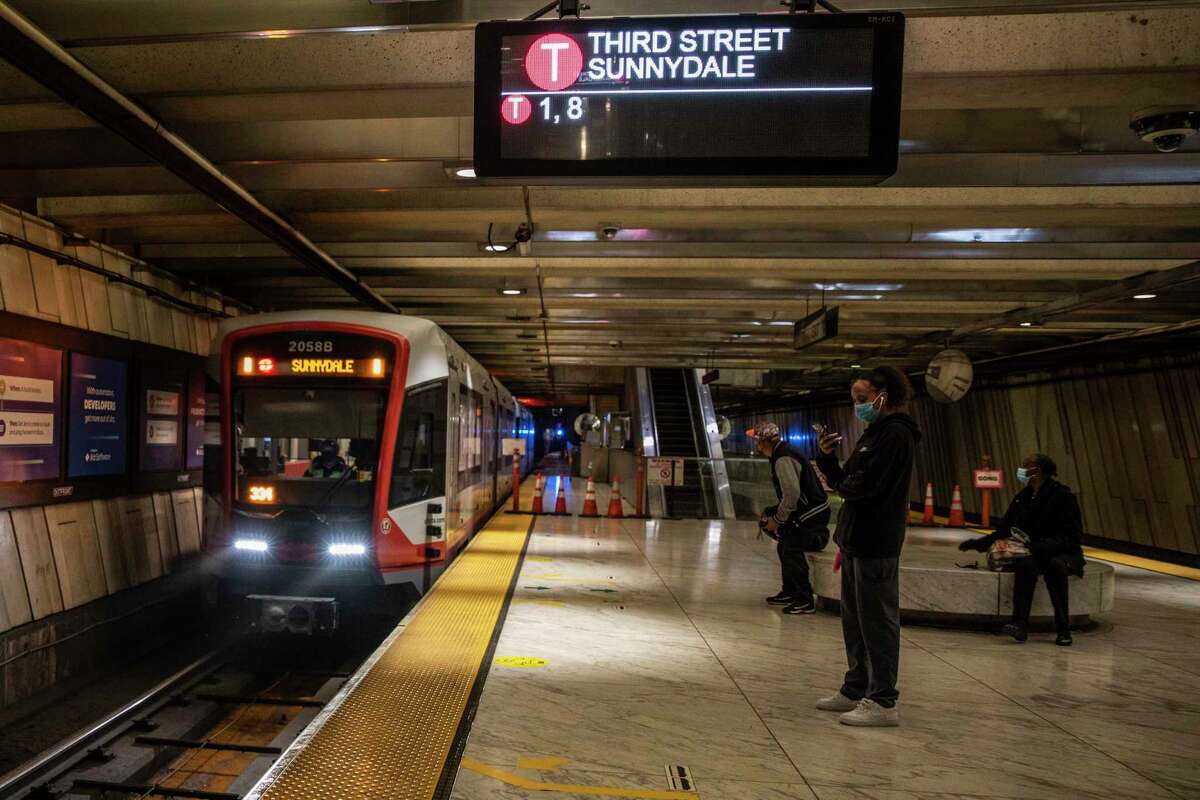 Passengers wait for the Muni T-Third Street train at Embarcadero Station in San Francisco.