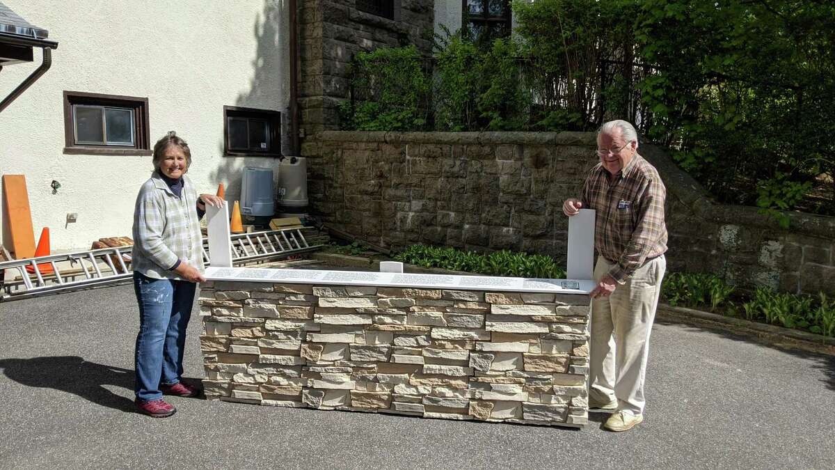 Bonnie Kearns and John Ward pose with the faux-stone base of the Prayer Wall, which was added to mimic the Western Wall in Jerusalem. Visitors wishing to keep their prayers private will be able to share them by writing messages on a piece of paper and concealing them within the cracks of the stones.