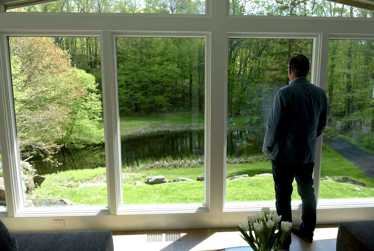 Jeff Phillips, from Madonna & Phillips Real Estate Group at William Pitt Sotheby’s International Realty, looks out the window of a new listing from Roxbury, Conn, on Thursday morning, May 13, 2021.