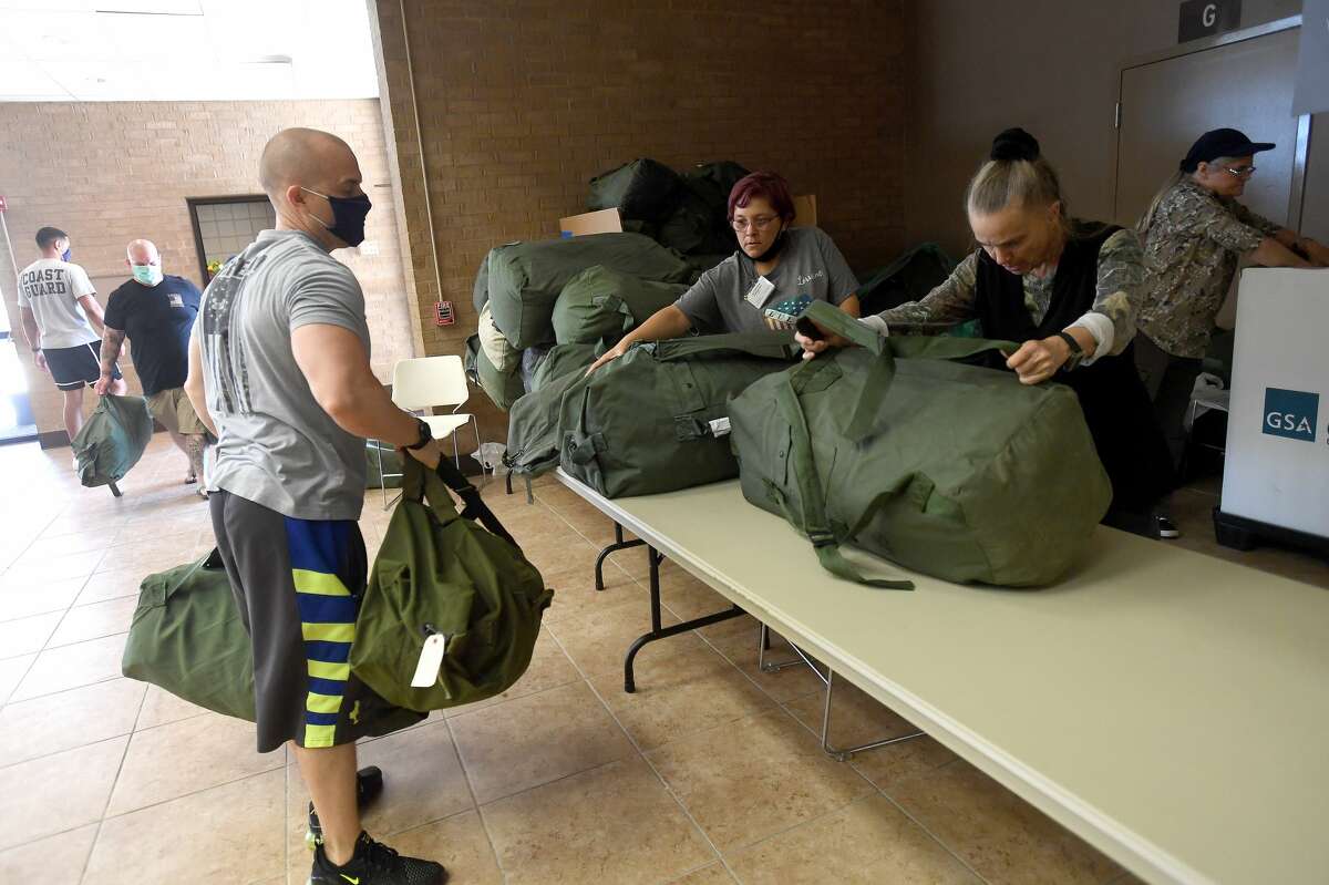 Members of Veterans 4 Veterans set up duffel bags filled with supplies to give away during Southeast Texas Stand Down 2021 in Port Arthur Friday. Numerouse veterans organizations as well as other health and community action services filled the Bob A. Bowers Civic Center for the event, which aims to connect veterans and the homeless with needed resources. A fall event will be held in Beaumont. Photo made Friday, May 14, 2021 Kim Brent/The Enterprise