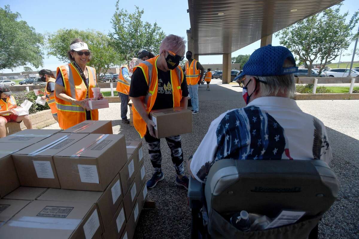 Volunteers with the Southeast Texas Food Bank hand out food boxes and snack bags during Southeast Texas Stand Down 2021 in Port Arthur Friday. Numerouse veterans organizations as well as other health and community action services filled the Bob A. Bowers Civic Center for the event, which aims to connect veterans and the homeless with needed resources. A fall event will be held in Beaumont. Photo made Friday, May 14, 2021 Kim Brent/The Enterprise