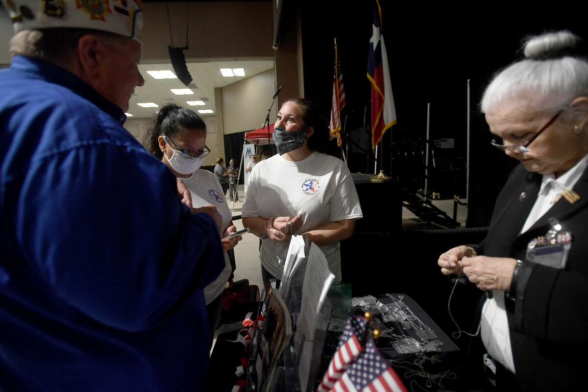 Susan Contreras (left) and Autumn Brown with SETX Civilian Task Force talk with Jim Rose at the VFW Post 4820 booth as Dorothy Peyton helps them find specialty branch dog tags during Southeast Texas Stand Down 2021 in Port Arthur Friday. Numerous veterans organizations as well as other health and community action services filled the Bob A. Bowers Civic Center for the event, which aims to connect veterans and the homeless with needed resources. A fall event will be held in Beaumont. Photo made Friday, May 14, 2021 Kim Brent/The Enterprise