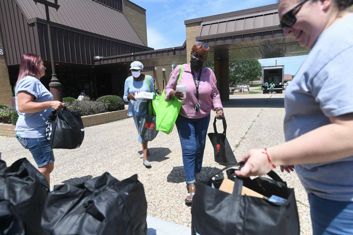 Wendy Alvarez (left) and Susan Gonzalez with the SETX Civilian Task Force hand out bags filled with supplies during Southeast Texas Stand Down 2021 in Port Arthur Friday. Numerouse veterans organizations as well as other health and community action services filled the Bob A. Bowers Civic Center for the event, which aims to connect veterans and the homeless with needed resources. A fall event will be held in Beaumont. Photo made Friday, May 14, 2021 Kim Brent/The Enterprise