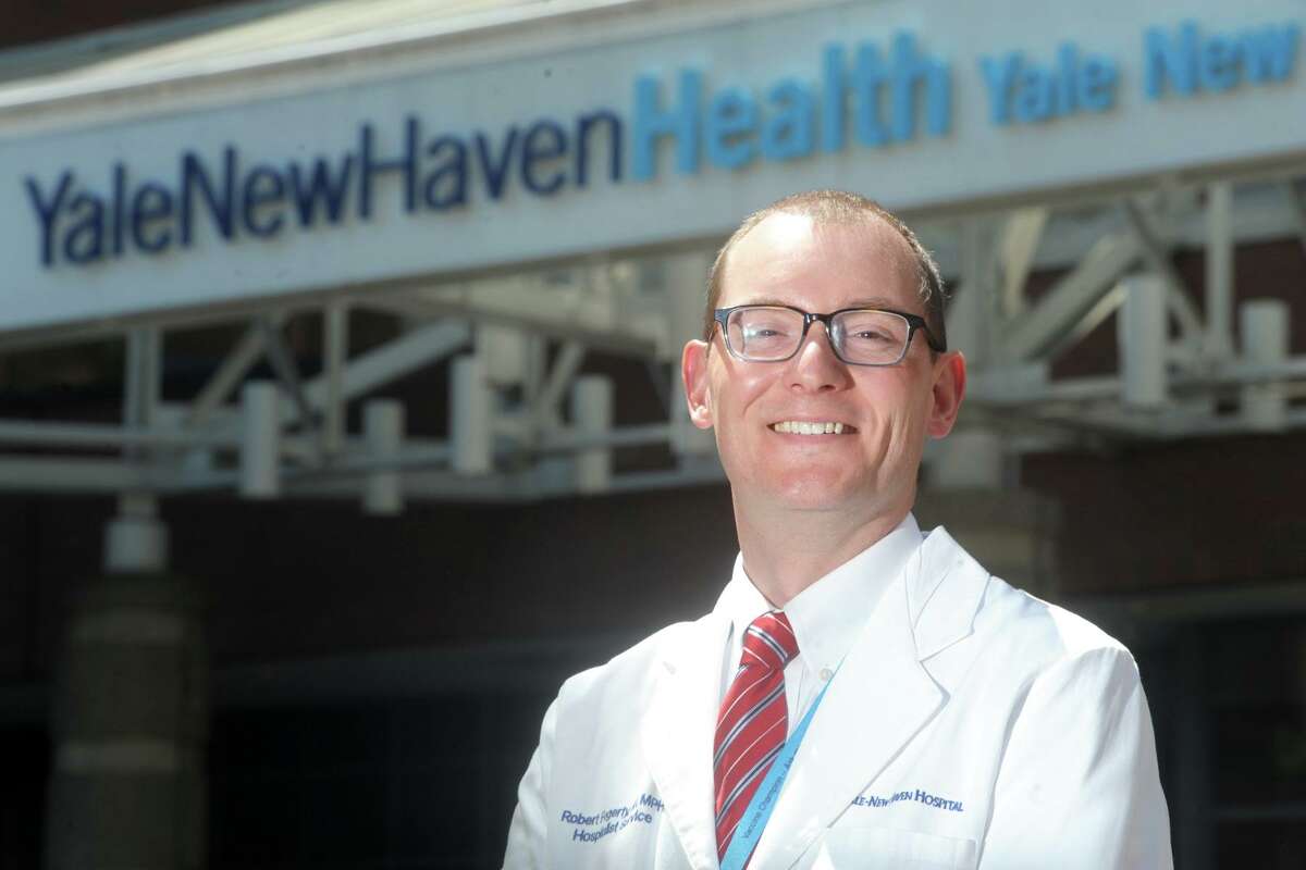 Dr. Rob Fogerty poses in front of Yale New Haven Hospital, in New Haven, Conn. May 14, 2021. Fogerty is director of bed resources at the hospital.