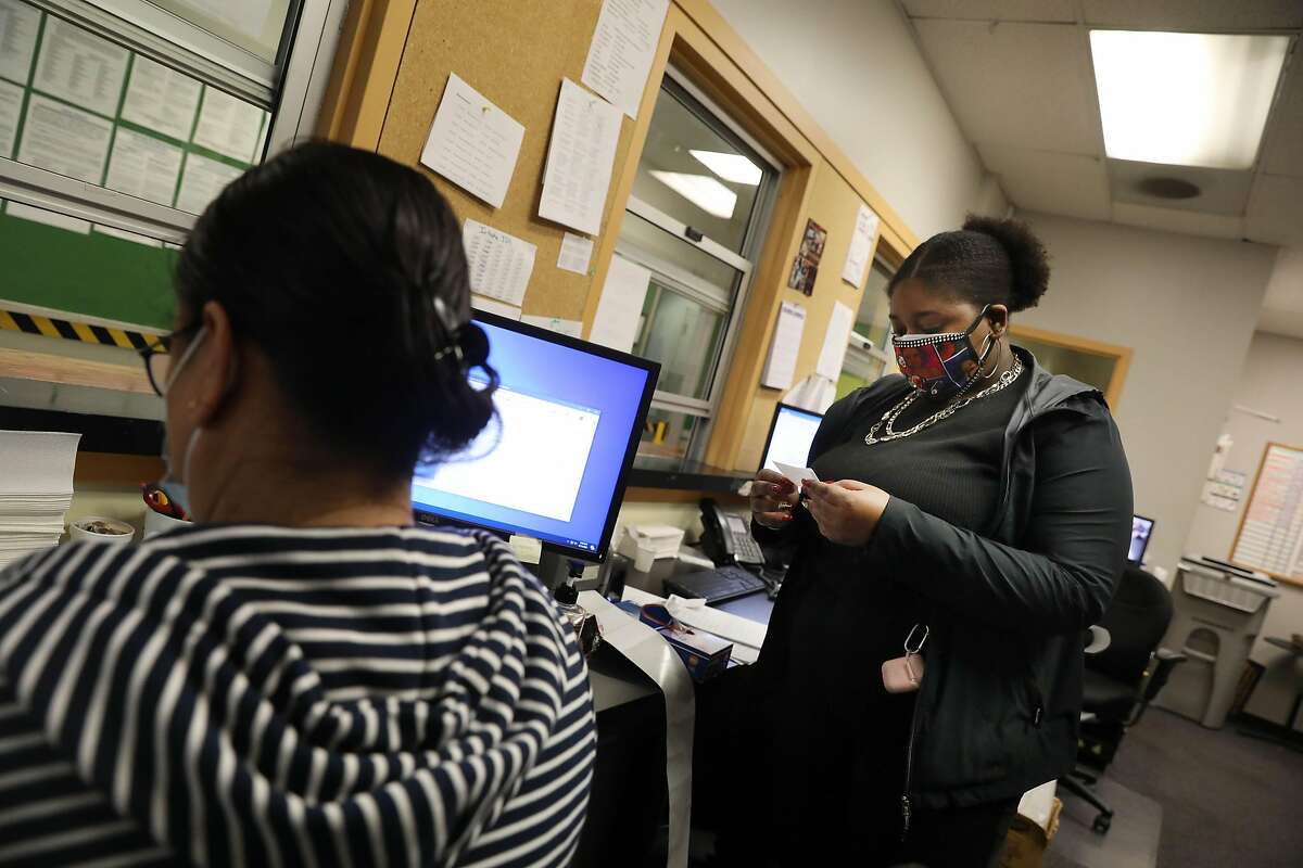 Fiscal clerk Lenise Beal collects a printed label while working the front desk of the medical office of Bay Area Addiction Research Treatment in San Francisco.