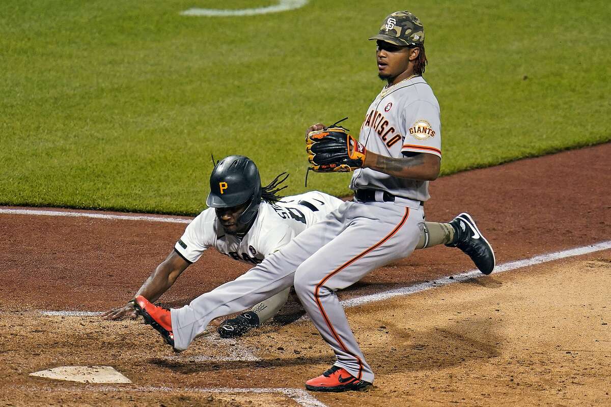Pittsburgh Pirates' Troy Stokes Jr., rear, scores on a wild pitch by San Francisco Giants relief pitcher Camilo Doval, right, during the seventh inning of a baseball game in Pittsburgh, Saturday, May 15, 2021. (AP Photo/Gene J. Puskar)
