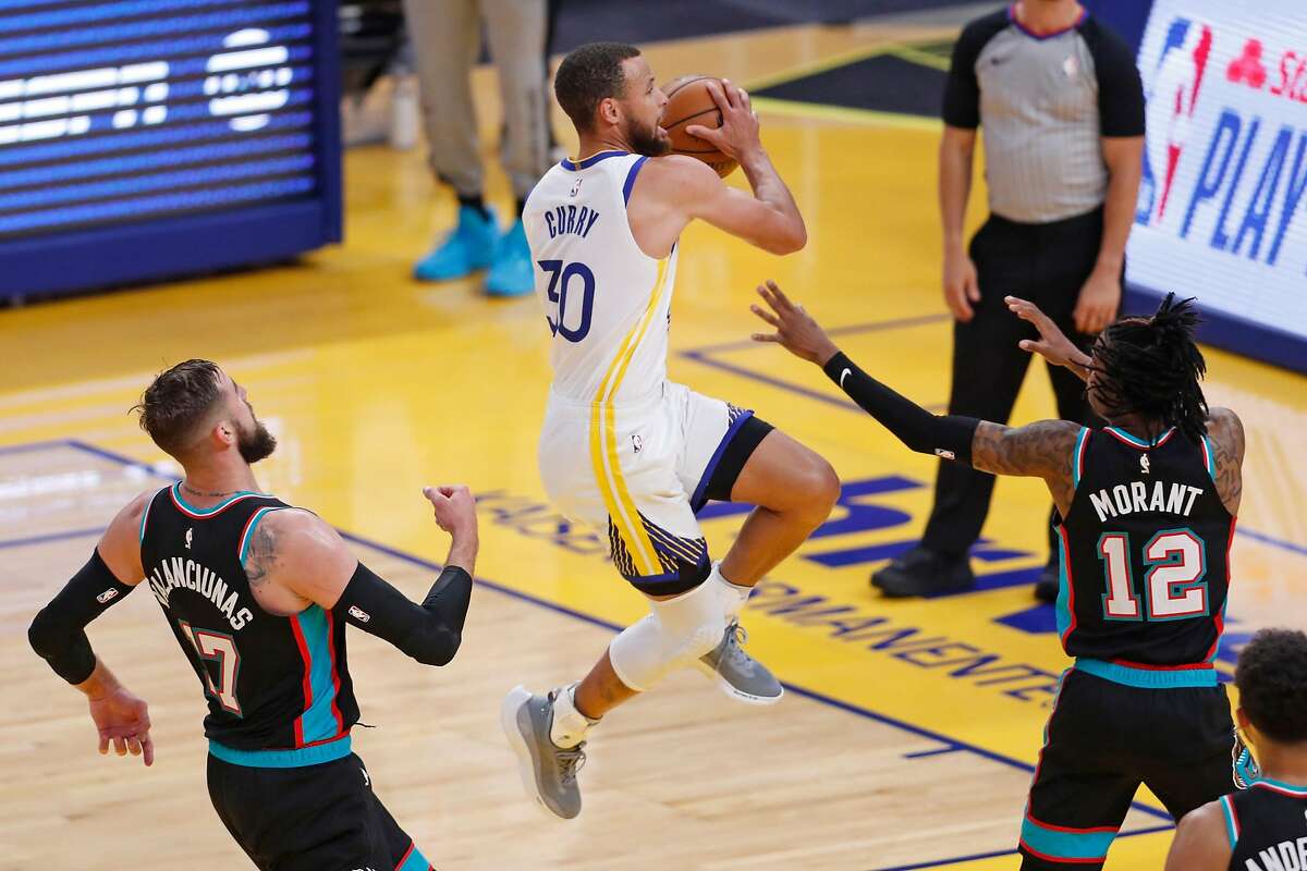 Golden State Warriors' Stephen Curry scores between Memphis Grizzlies' Jonas Valanciunas and Ja Morant in 1st quarter during NBA game at Chase Center in San Francisco, Calif., on Sunday, May 16, 2021.