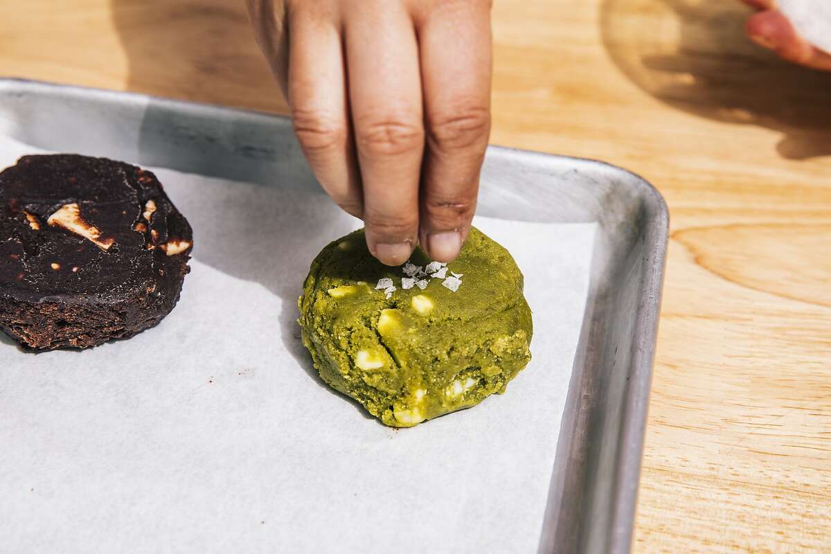 Elaine Lau, chef and co-founder of Sunday Bakeshop in Oakland, places Maldon salt on top of matcha White Rabbit cookie dough prior to baking.