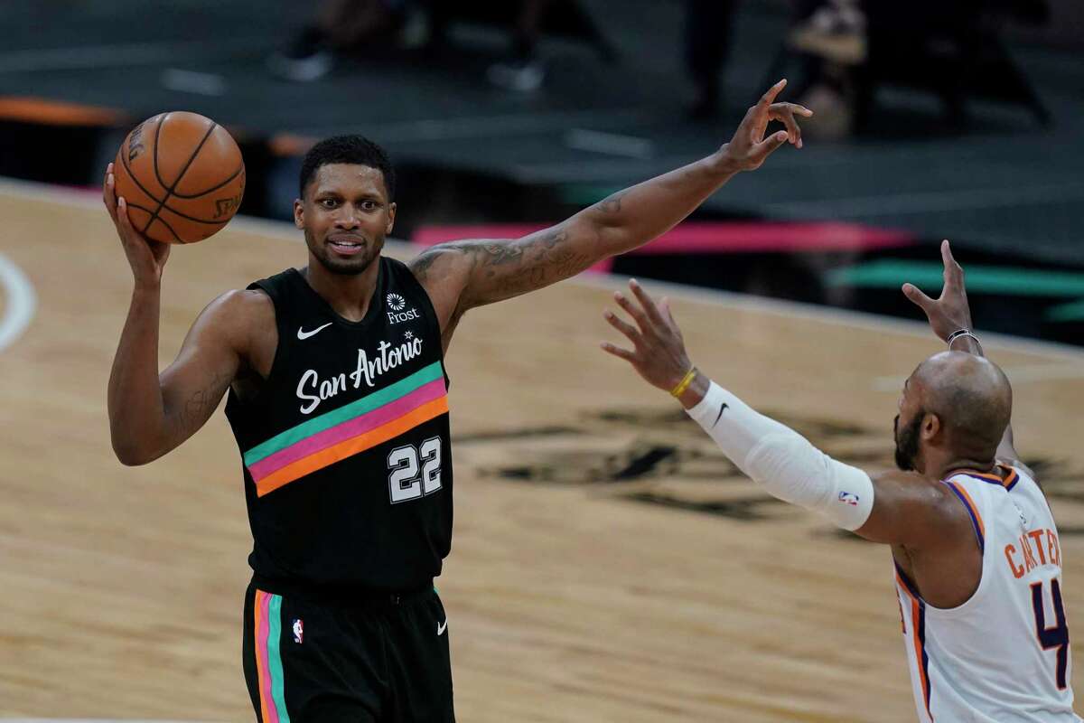 San Antonio Spurs forward Rudy Gay (22) looks to pass around Phoenix Suns guard Jevon Carter (4) during the second half of an NBA basketball game in San Antonio, Sunday, May 16, 2021. (AP Photo/Eric Gay)