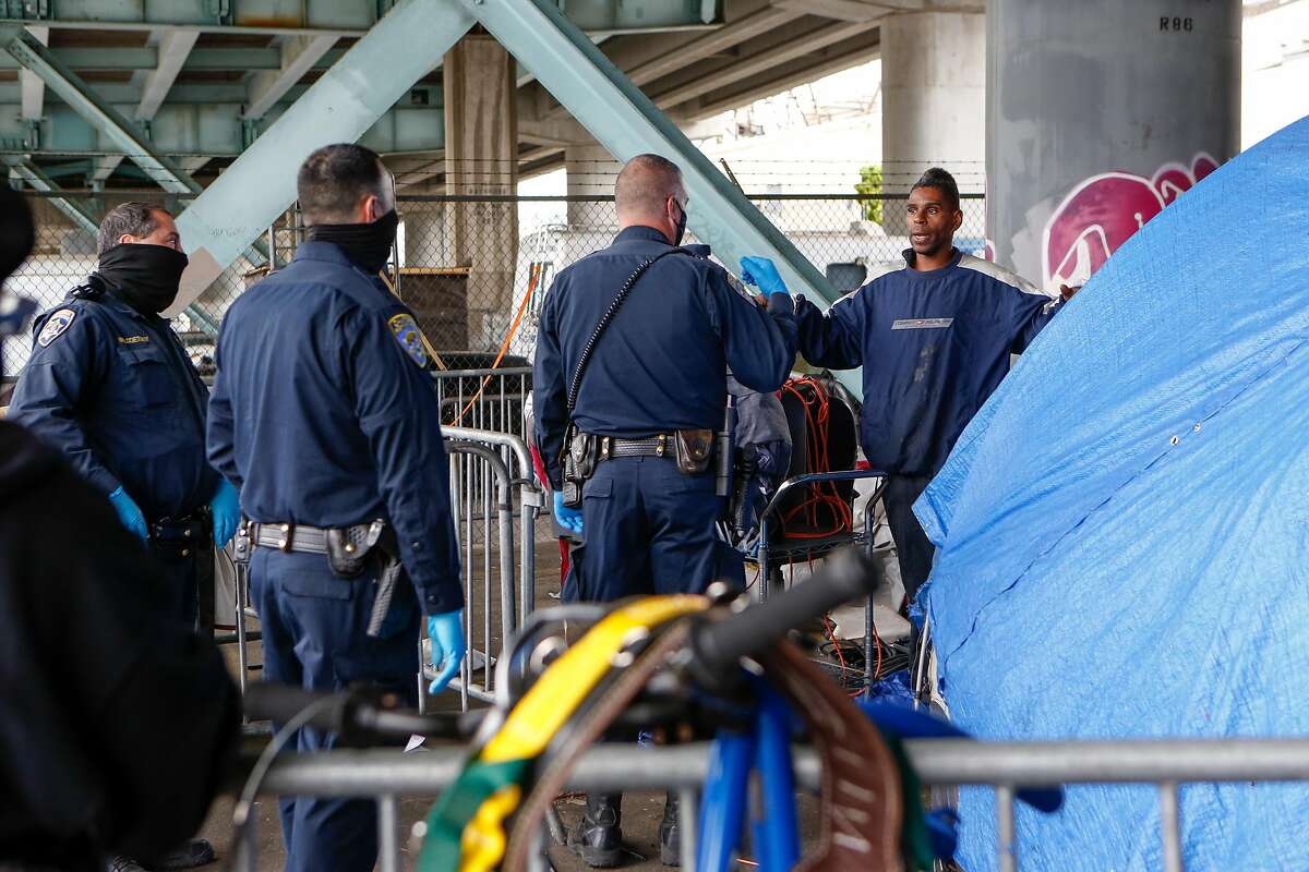 Officers insist to Ashante Jones that he needs to move his belongs immediately at the Merlin Street encampment just before a sweep performed by California Highway Patrol and CalTrans on Monday, May 17, 2021 in San Francisco, Calif.