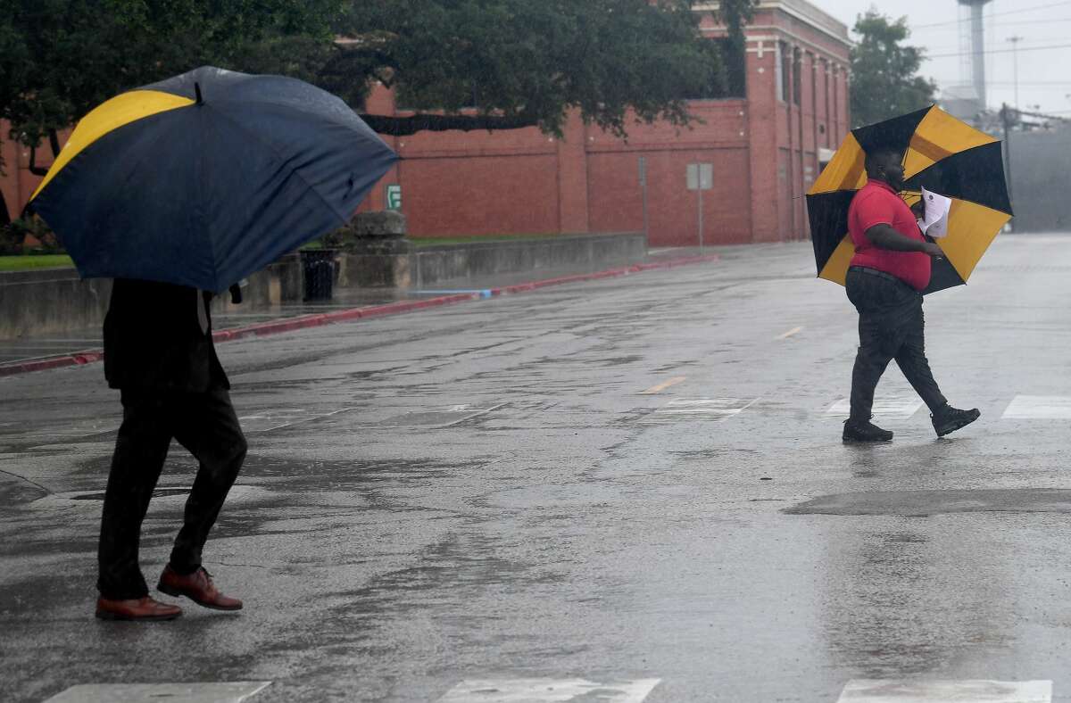 Pedestrians shelter from the rain as they make their way out of the Jefferson Countny Courthouse as overnight storms and heavy rain persisted throughout the morning and into the afternoon. Storms and heavy rain are predicted to last through the week. Photo made Monday, May 17, 2021 Kim Brent/The Enterprise