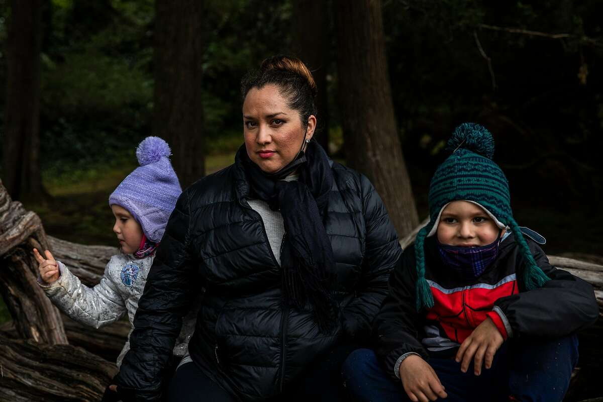 Lily Marquez sits for a portrait with daughter Mia (left) and son Jeremiah at Mother’s Meadow in Golden Gate Park.