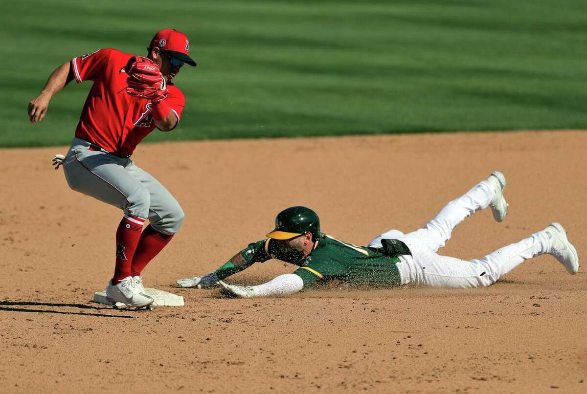 Luis Barrera (13) slides in safe to second on his double in the sixth inning as the Oakland Athletics played the Los Angeles Angels at Hohokam Stadium in Mesa, Ariz., on Friday, March 5, 2021.