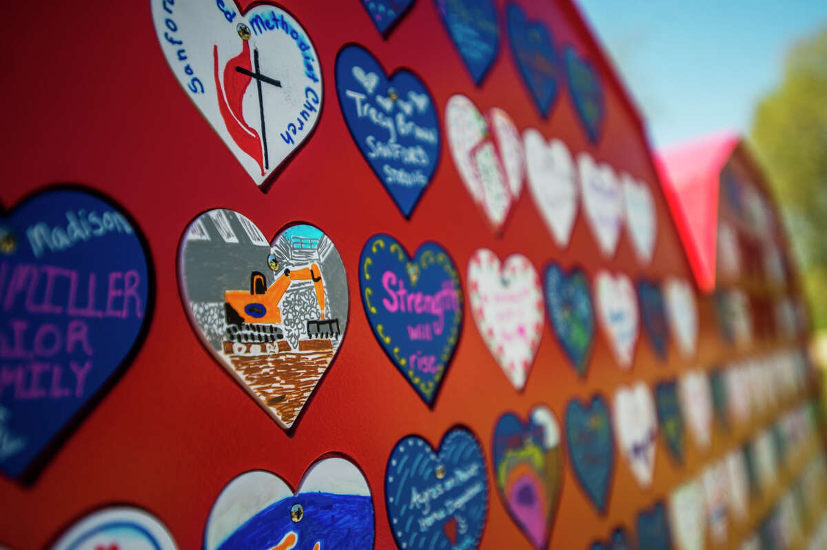 Volunteers work to install small decorated hearts onto the large "Sanford Strong" heart Tuesday, May 18, 2021 in downtown Sanford. (Katy Kildee/kkildee@mdn.net)