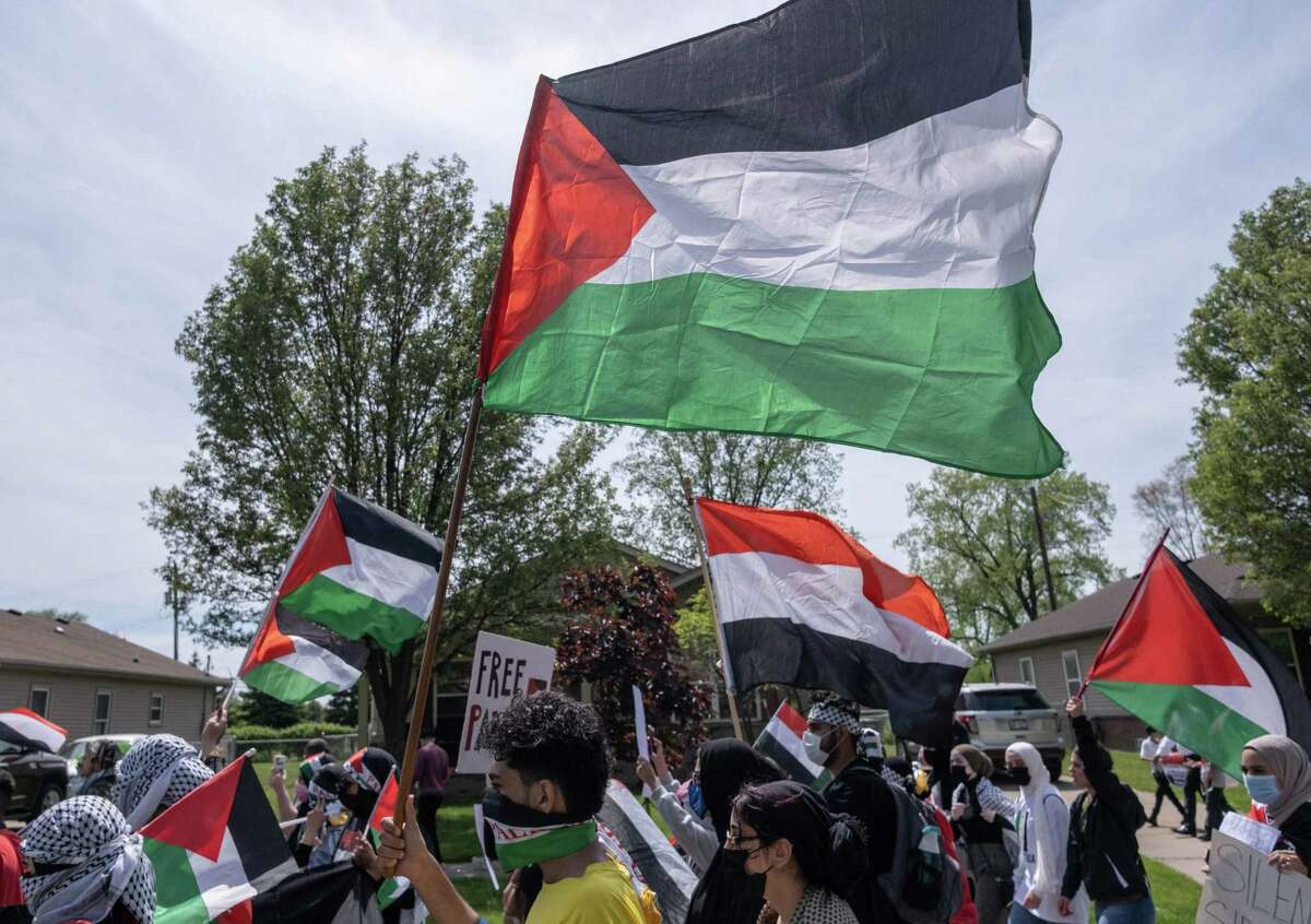 Protesters march through neighborhoods near a Ford Motor Company plant in Dearborn, Michigan on May 18, 2021, where US President Joe Biden is touring, to protest the Biden's continued support for Benjamin Netanyahu's administration, and the on going Israeli army actions in Gaza, and the forced removal of Palestinian families in Sheikh Jarrah in East Jerusalem. - US President Joe Biden, having resisted joining other world leaders and much of his own Democratic party in calling for an immediate end to hostilities, told Netanyahu Monday night he backs a ceasefire, but stopped short of demanding a truce. (Photo by SETH HERALD / AFP) (Photo by SETH HERALD/AFP via Getty Images)