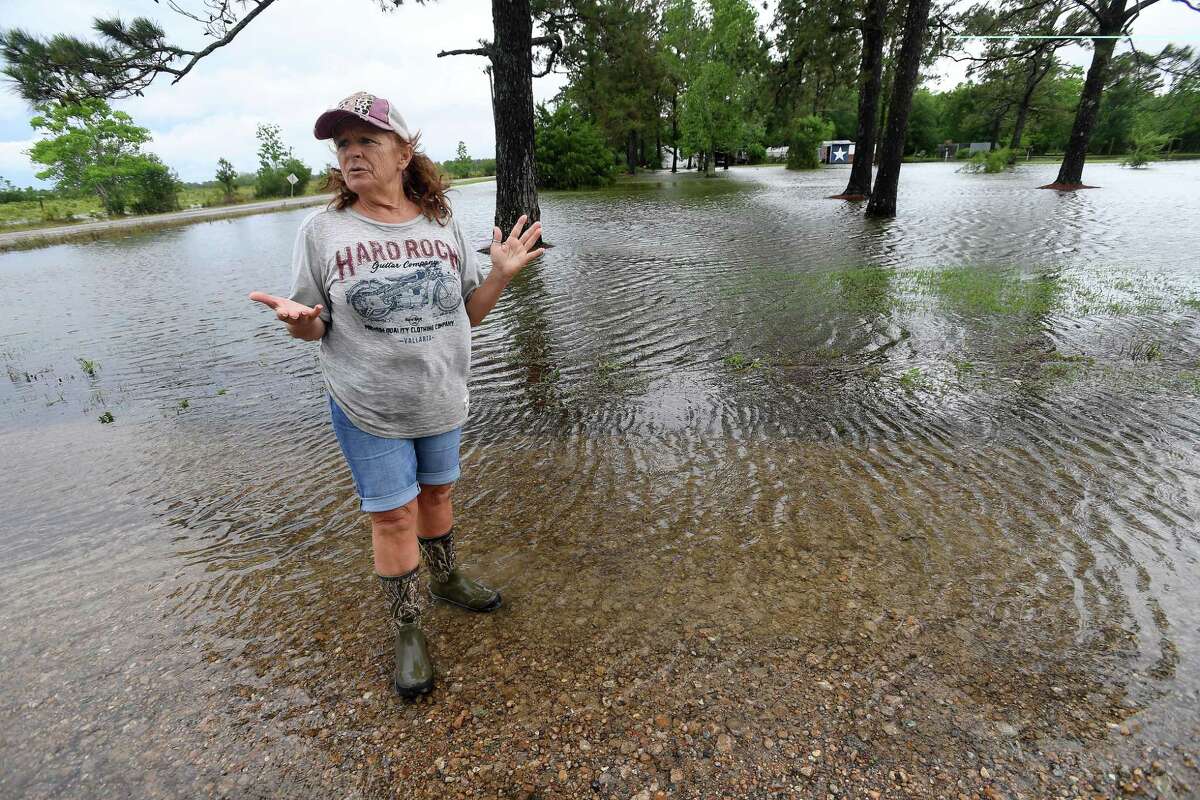 Julie Meadows talks about the flooding she got in her home on Boyt Road in Fannett Tuesday. The area received over a foot of rainfall Monday, flooding area bayous and several yards and homes. This is the third time Meadows' home has flooded, and she believes a drainage ditch at the back of her property, which is overgrown and has been neglected for years, is largely to blame. Photo made Tuesday, May 18, 2021 Kim Brent/The Enterprise