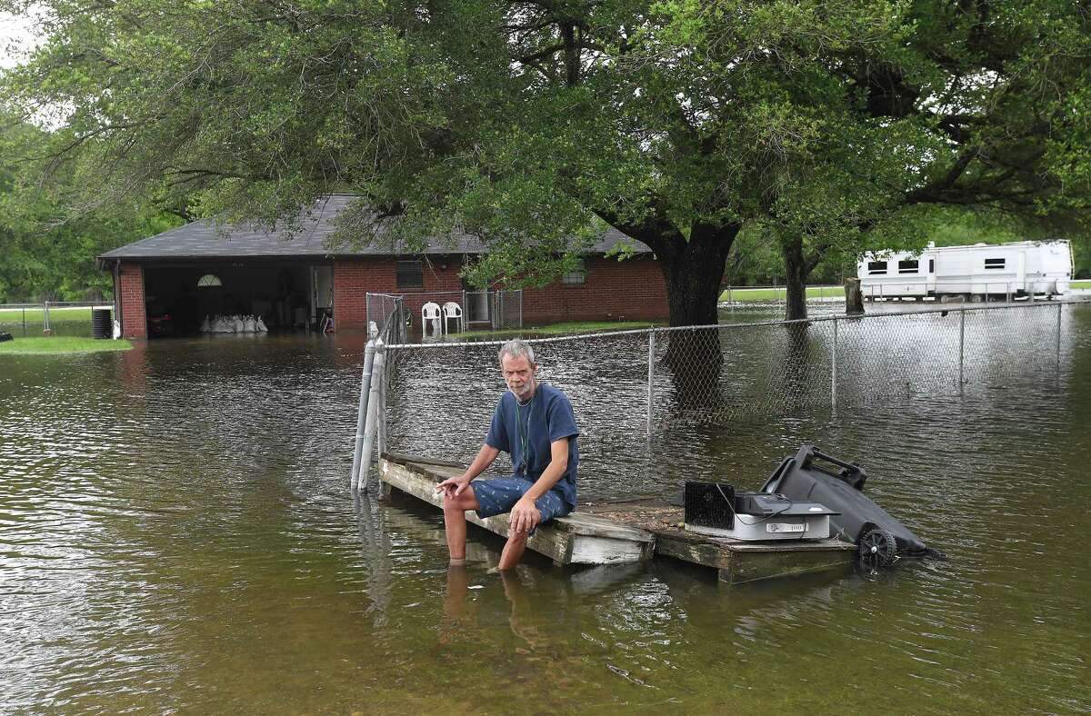 David O'Pry takes a break from moving articles out of his sister's flooded home in Fannett Tuesday. The area received over a foot of rainfall Monday, flooding area bayous and several yards and homes. Photo made Tuesday, May 18, 2021 Kim Brent/The Enterprise