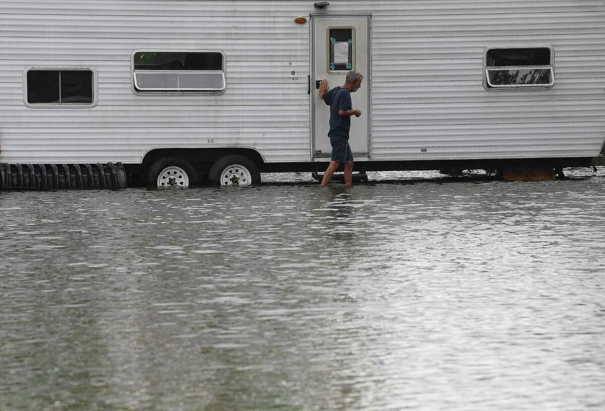 David O'Pry makes his way through the flooded yard surrounding his camper on FM 365 in Fannett Tuesday. He worries that additional rainfall might impact his home taking on water. The area received over a foot of rainfall Monday, flooding area bayous and several yards and homes. Photo made Tuesday, May 18, 2021 Kim Brent/The Enterprise