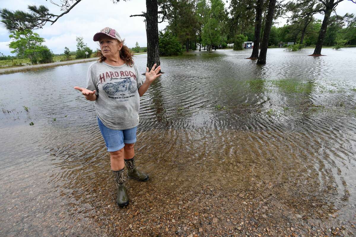 Julie Meadows talks about the flooding she got in her home on West Clubb Road in Fannett Tuesday. The area received over a foot of rainfall Monday, flooding area bayous and several yards and homes. This is the third time Meadows' home has flooded, and she believes a drainage ditch at the back of her property, which is overgrown and has been neglected for years, is largely to blame. Photo made Tuesday, May 18, 2021 Kim Brent/The Enterprise