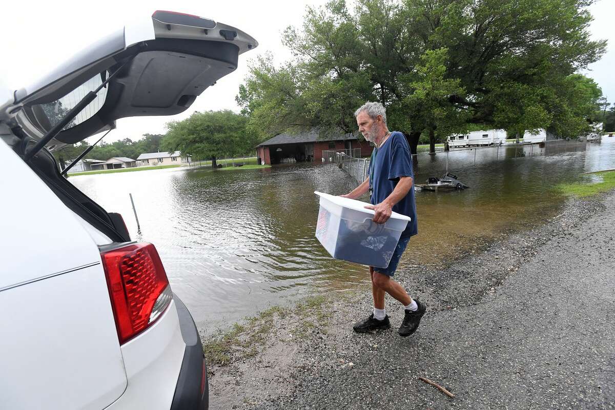 David O'Pry carries out clothes from his sister's home next door to his camper in Fannett Tuesday. Lisa Brown is planning to stay at a home she and her husband are renovating in Silsbee after their house on FM 365 flooded, with additional heavy rainfall on the way this week. The area received over a foot of rainfall Monday, flooding area bayous and several yards and homes. Photo made Tuesday, May 18, 2021 Kim Brent/The Enterprise