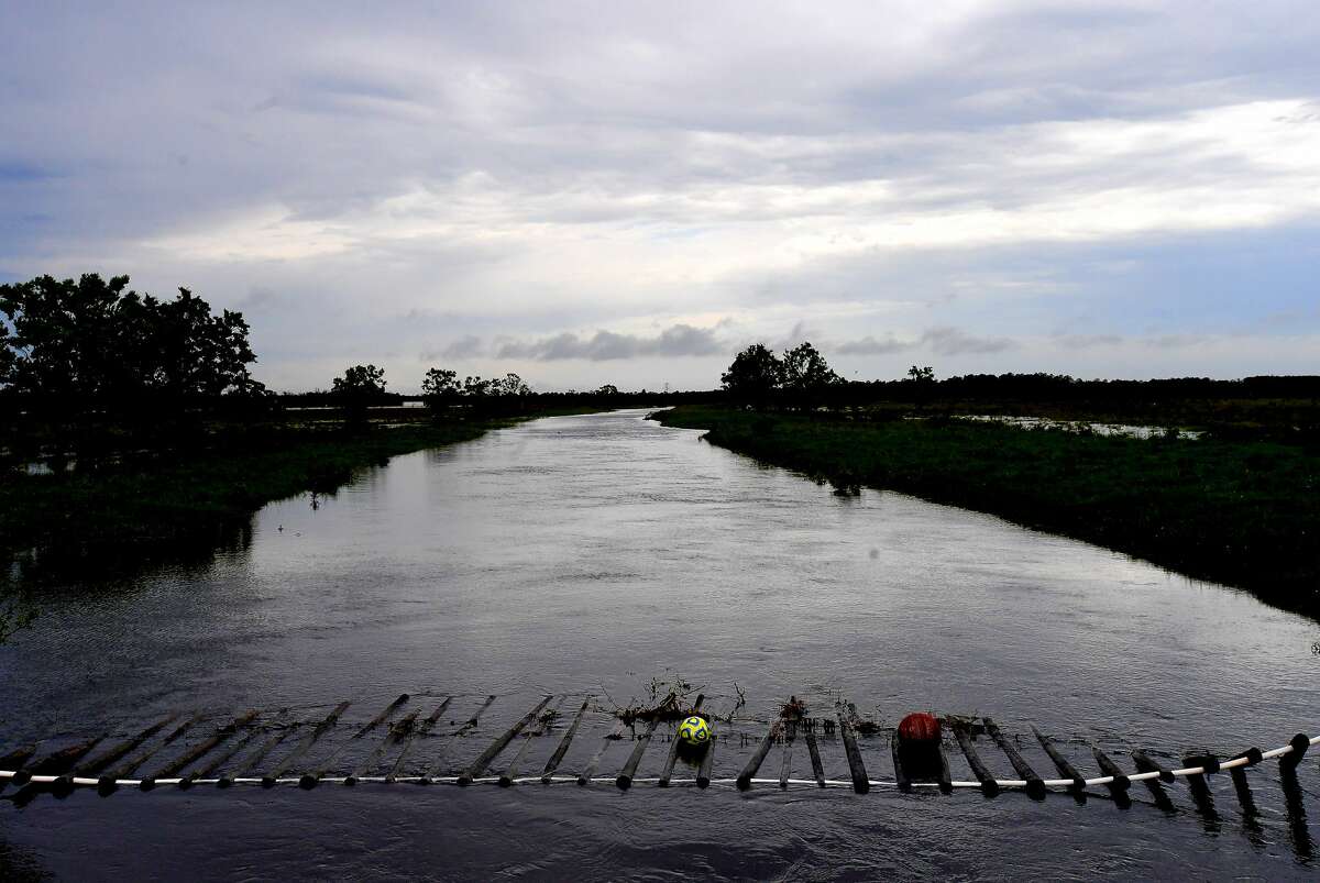 Children's toys that drifted away in floodwaters are caught in the fencing of a high canal along West Clubb Road in Fannett Tuesday. The area received over a foot of rainfall Monday, flooding area bayous and several yards and homes. Photo made Tuesday, May 18, 2021 Kim Brent/The Enterprise