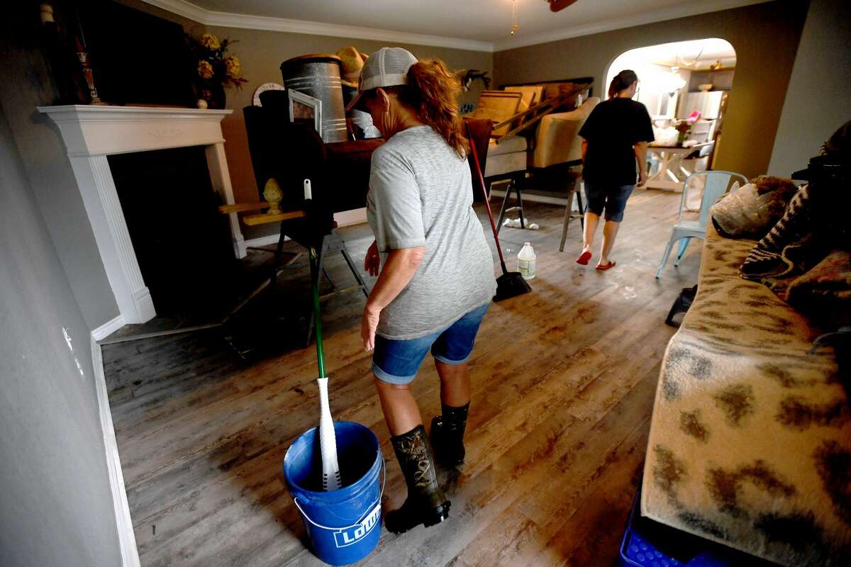 Julie Meadows walks through her home on West Clubb Road in Fannett Tuesday. The area received over a foot of rainfall Monday, flooding area bayous and several yards and homes. This is the third time Meadows' home has flooded, and she believes a drainage ditch at the back of her property, which is overgrown and has been neglected for years, is largely to blame. Photo made Tuesday, May 18, 2021 Kim Brent/The Enterprise