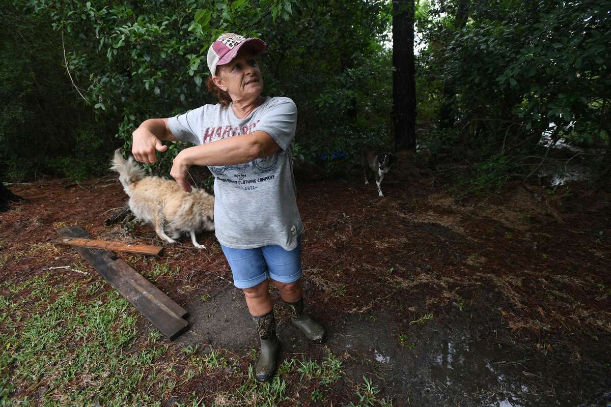 Julie Meadows talks about persistent flooding issues as she stands near the drainage ditch running behind her property on West Clubb Road in Fannett Tuesday. The area received over a foot of rainfall Monday, flooding area bayous and several yards and homes. This is the third time Meadows' home has flooded, and she believes the ditch, which is overgrown and has been neglected for years, is largely to blame. Photo made Tuesday, May 18, 2021 Kim Brent/The Enterprise