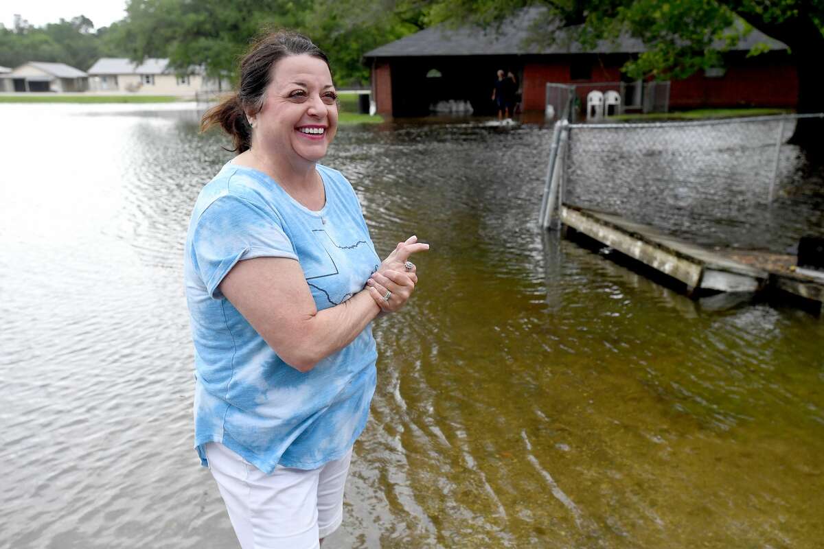 Lisa Brown recalls how her first flooding incident in Harvey ultimately led to her marriage as she stands outside her now thrice-flooded home in Fannett Tuesday. The area received over a foot of rainfall Monday, flooding area bayous and several yards and homes. Photo made Tuesday, May 18, 2021 Kim Brent/The Enterprise