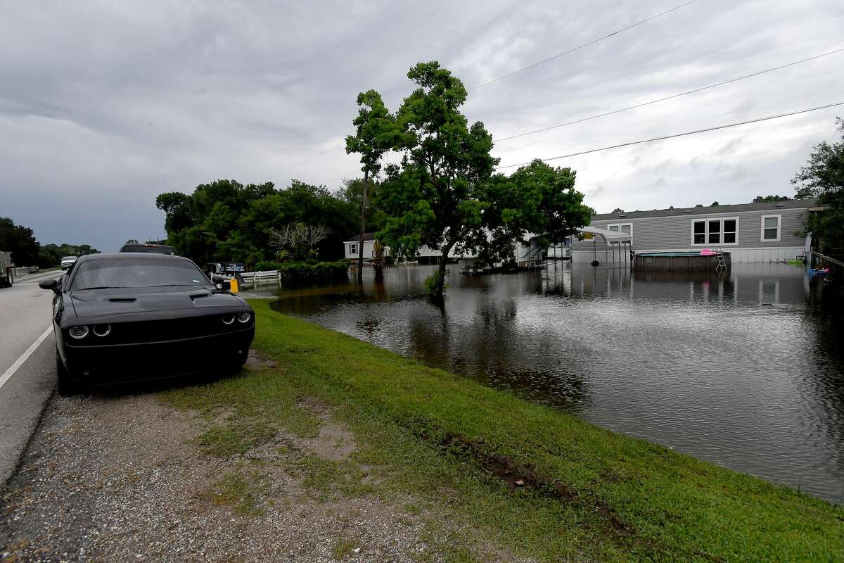 Home owners along FM 365 in Fannett leave their cars parked on higher roadside ground Tuesday. The area received over a foot of rainfall Monday, flooding area bayous and several yards and homes. Photo made Tuesday, May 18, 2021 Kim Brent/The Enterprise