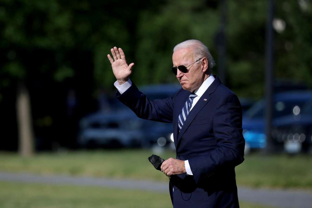 WASHINGTON, DC - MAY 19: U.S. President Joe Biden waves as he walks to Marine One for a departure from the Ellipse near the White House on May 19, 2021 in Washington, DC. President Biden is traveling to New London, Connecticut, where he will deliver a keynote address during the United States Coast Guard Academy's  commencement ceremony.