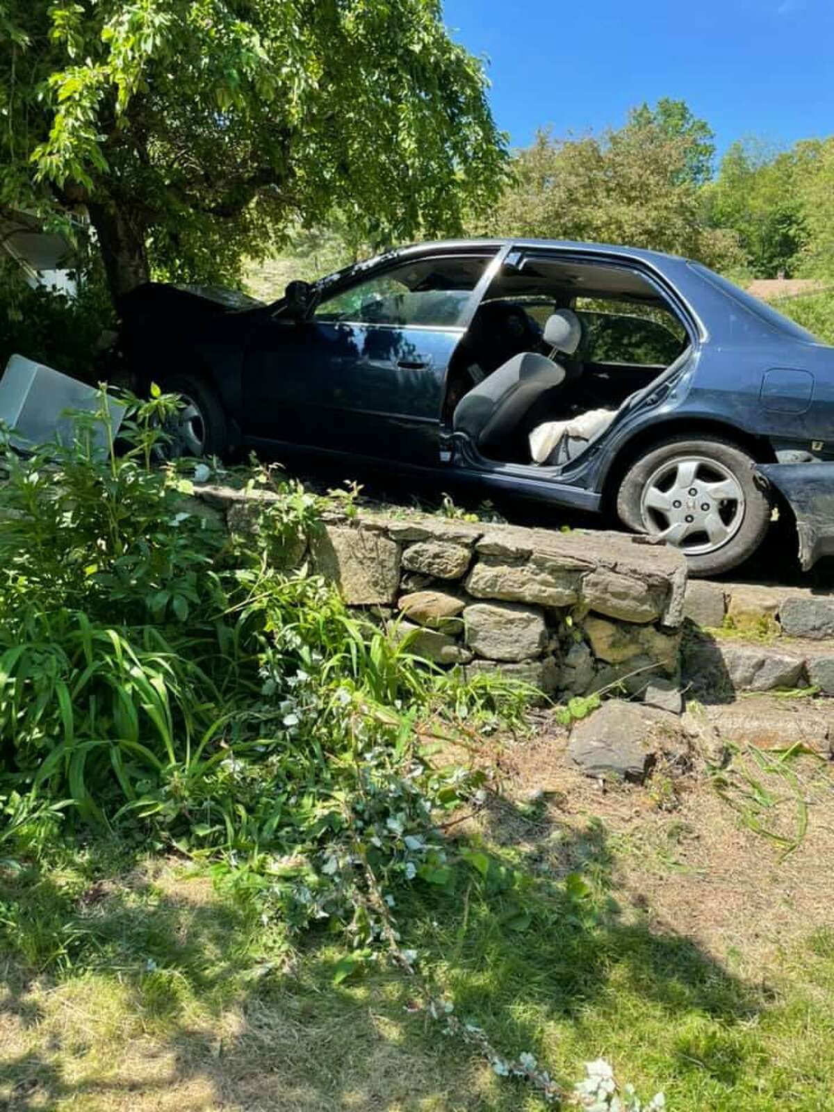 Newtown police investigate car crash into tree, house