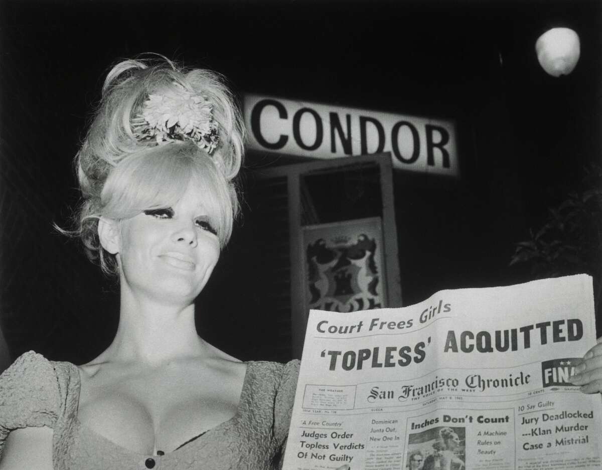 A 1960s file photo of Carol Doda showing off the headlines in front of the Condor Club where she performed.