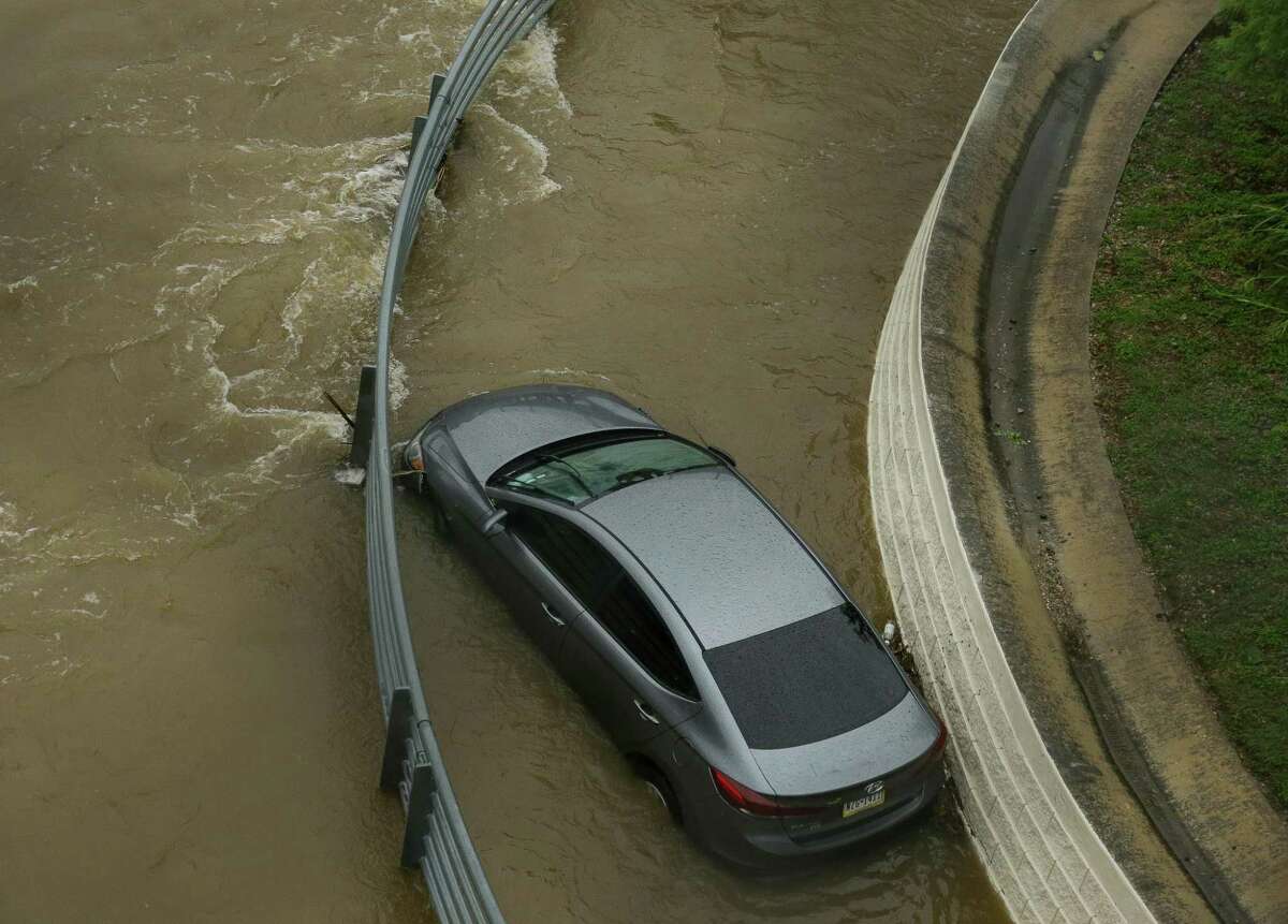 A vehicle can be seen stuck in a flooded bend of White Oak Bayou Greenway Trail, near Hogan Street on Wednesday, May 19, 2021, in Houston.