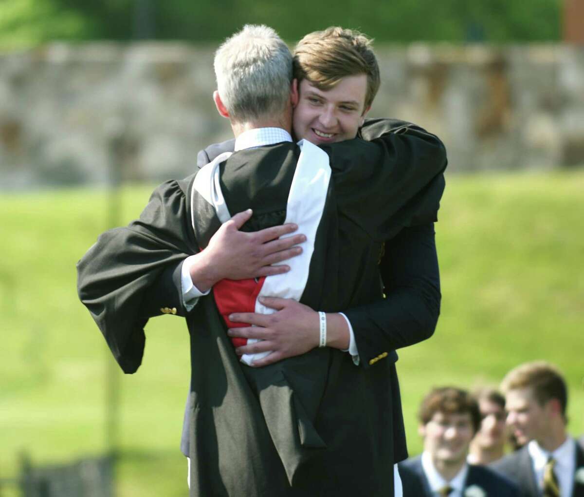 Boland Faughnan hugs Head of School Thomas Philip while receiving his diploma at the 2021 commencement ceremony at Brunswick School in Greenwich, Conn. Wednesday, May 19, 2021. 104 students graduated during the outdoor ceremony at Cosby Field, featuring a virtual commencement speech by Connecticut Gov. Ned Lamont.