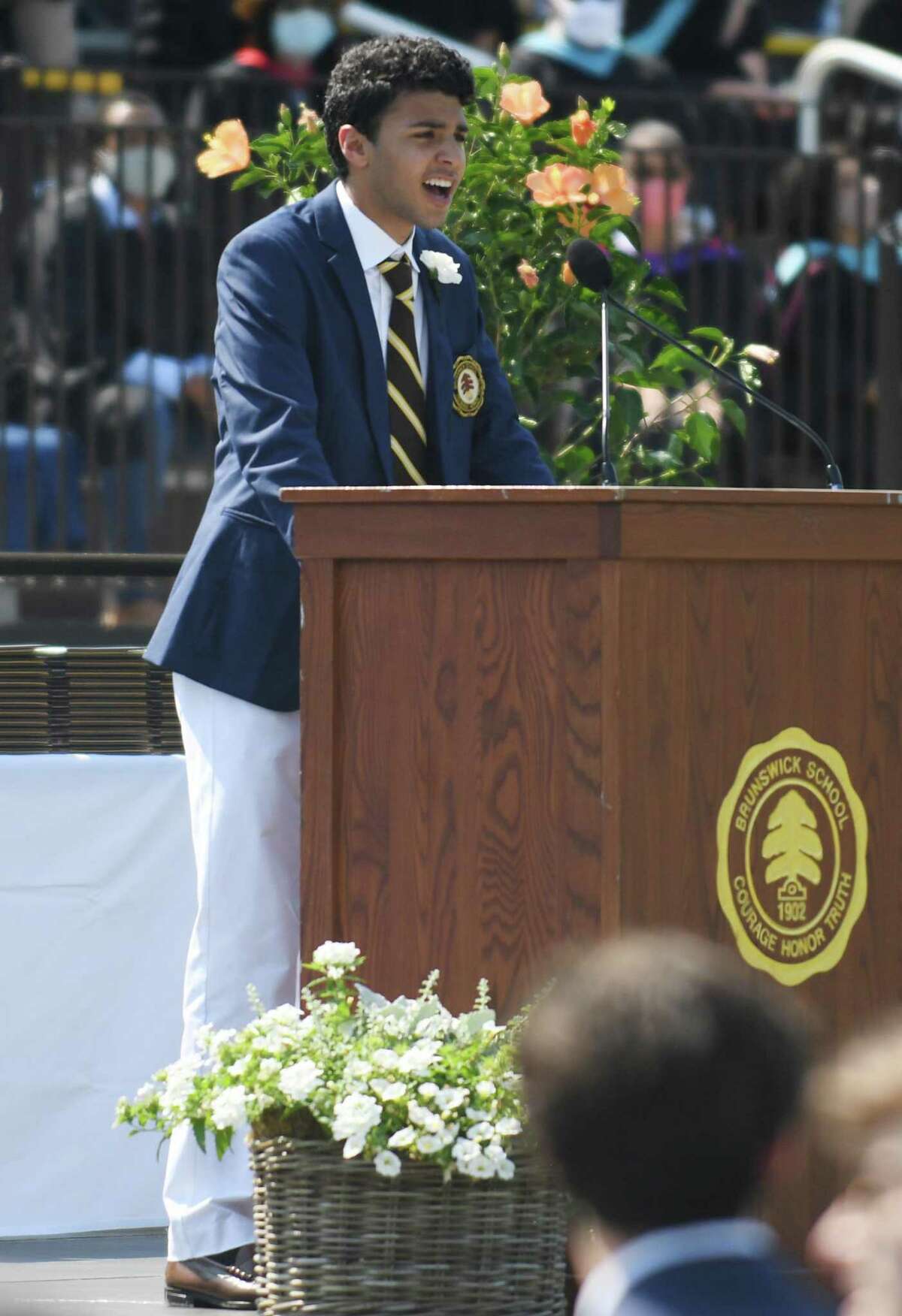 Valedictorian and "Ivy Speaker" Ali Hindy speaks at the 2021 commencement ceremony at Brunswick School in Greenwich, Conn. Wednesday, May 19, 2021. 104 students graduated during the outdoor ceremony at Cosby Field, featuring a virtual commencement speech by Connecticut Gov. Ned Lamont.