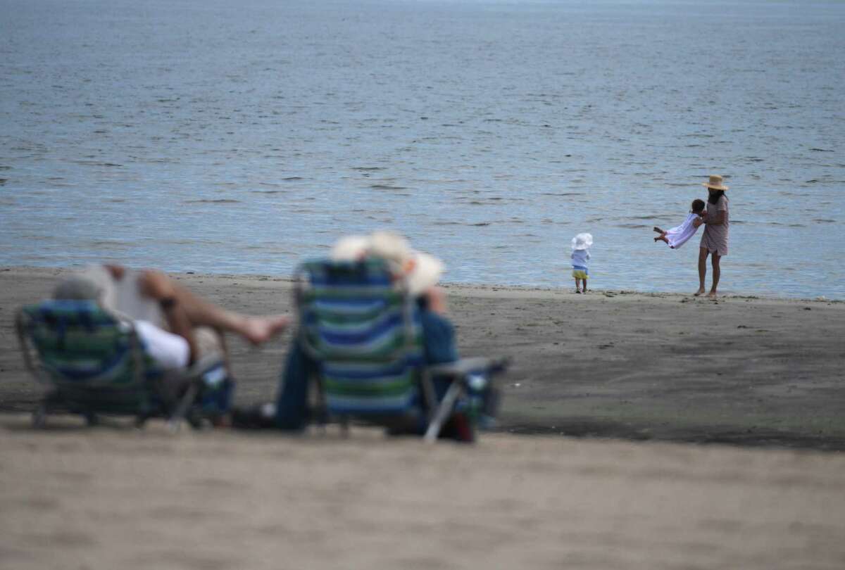 A Riverside mother and her children play on the beach at the Greenwich Point Park in Old Greenwich, Conn. Thursday, May 20, 2021.