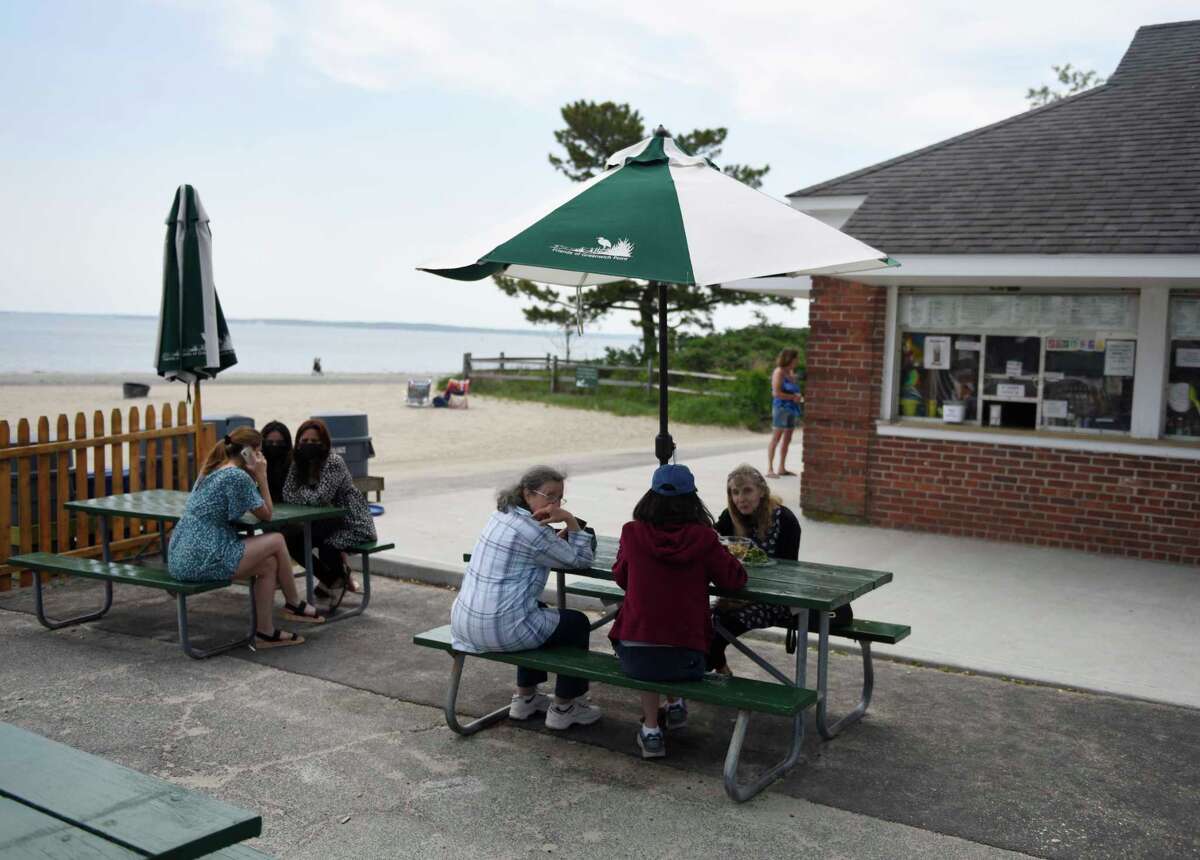 Beachgoers relax outside the snack bar at the Greenwich Point Park beach in Old Greenwich, Conn. Thursday, May 20, 2021.