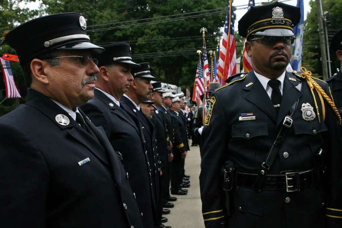 Bridgeport fire Captain Louis Rivera, left, and Norwalk police officer Irving Bolling, right, stand in formation before entering Saint Catherine of Siena in Trumbull. The Diocese of Bridgeport commemorated the ninth anniversary of 9/11 by honoring law enforcement, fire and emergency service personnel in a Blue Mass on Sunday, September, 12, 2010.