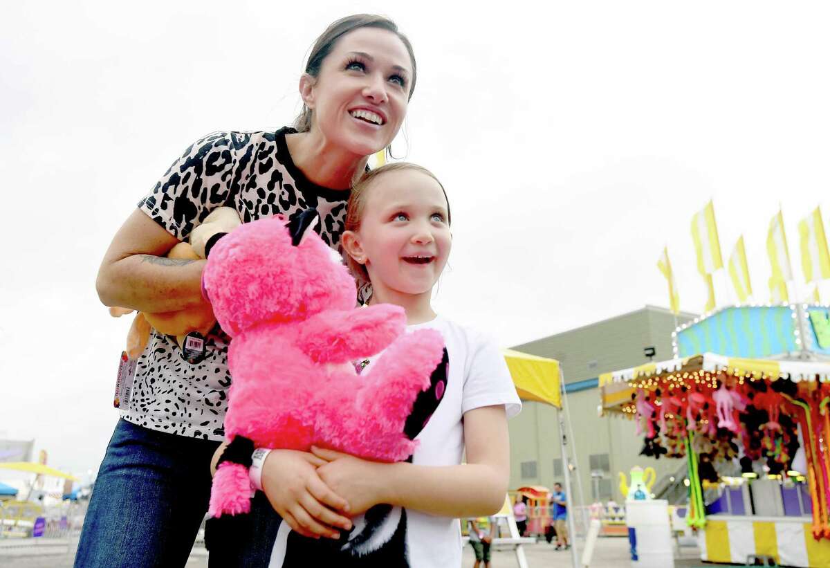 Falon Duprie and daughter Baylee watch as family ride the Crazy Mouse, a new rollercoaster, on the opening night of the YMBL South Texas State Fair Thursday. Photo made Thursday, May 20, 2021 Kim Brent/The Enterprise
