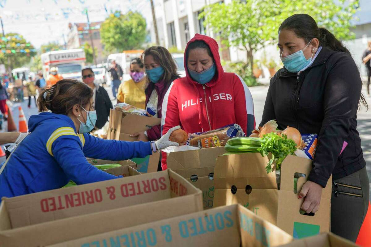 五月份，贝尔金·埃雷拉(右)和她的妹妹迪莱尼亚·埃尔南德斯从旧金山的教会食品中心收到一盒食品杂货。加州联合慈善基金会(United Ways of California)的一项研登录必赢亚洲究显示，湾区约有60.8万户家庭的收入不足以支付住房、食品、医疗和儿童保育等日常必需品的费用。