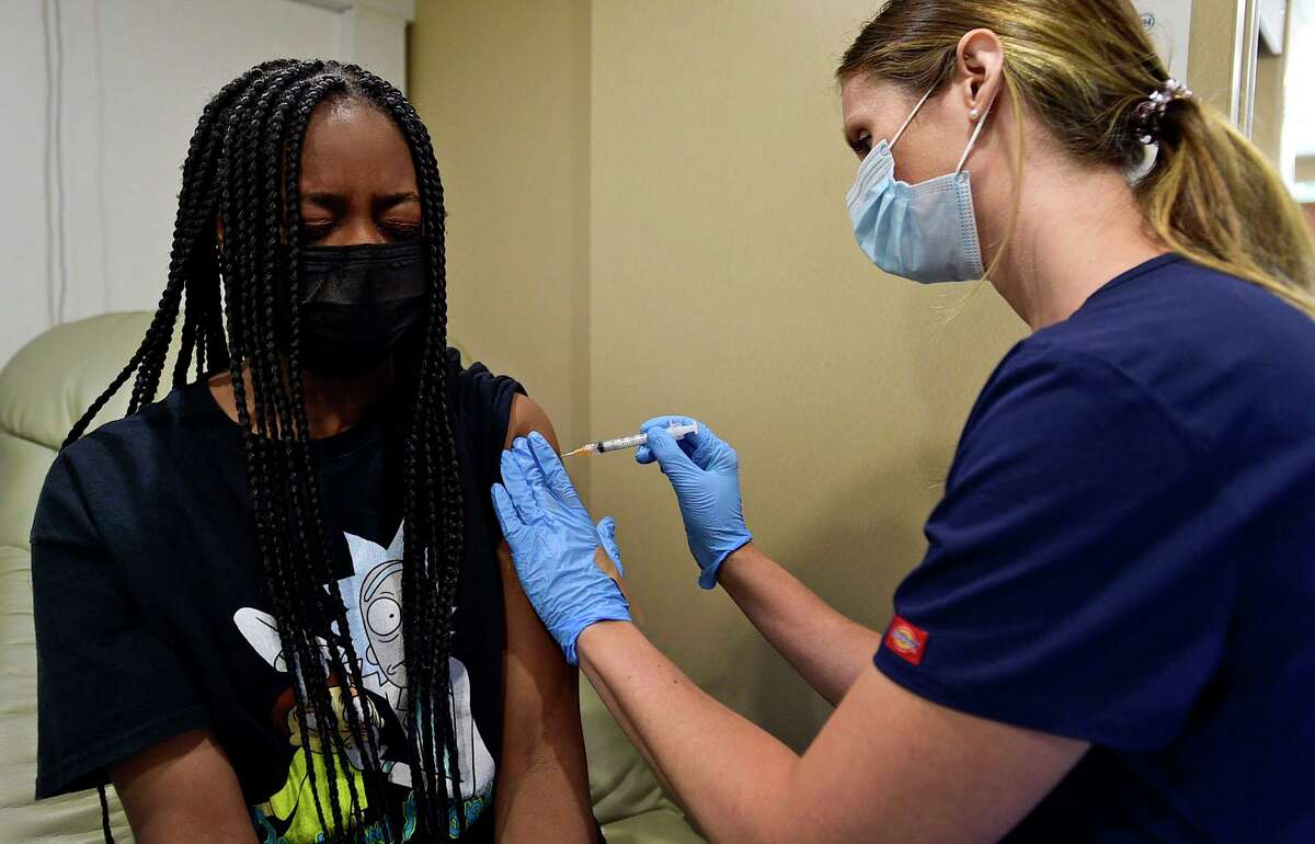 Students including West Rocks Middle School 8th grader Kennedy Ferdinand get vaccinated by RN Elin Jokl at the Norwalk Public Schools COVID vaccine clinic Thursday, May 20, 2021, in the Norwalk Community Health Center mobile unit at West Rocks Elementary School in Norwalk, Conn.