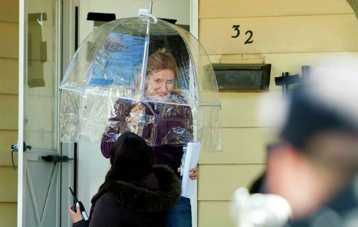 Actor Jessica Chastain exits the home used as a set for the upcoming Netfix movie ‘The Good Nurse’ in Stamford, Conn., on Friday April 23, 2021. Chastain is using the umbrella to protect her hair between takes.