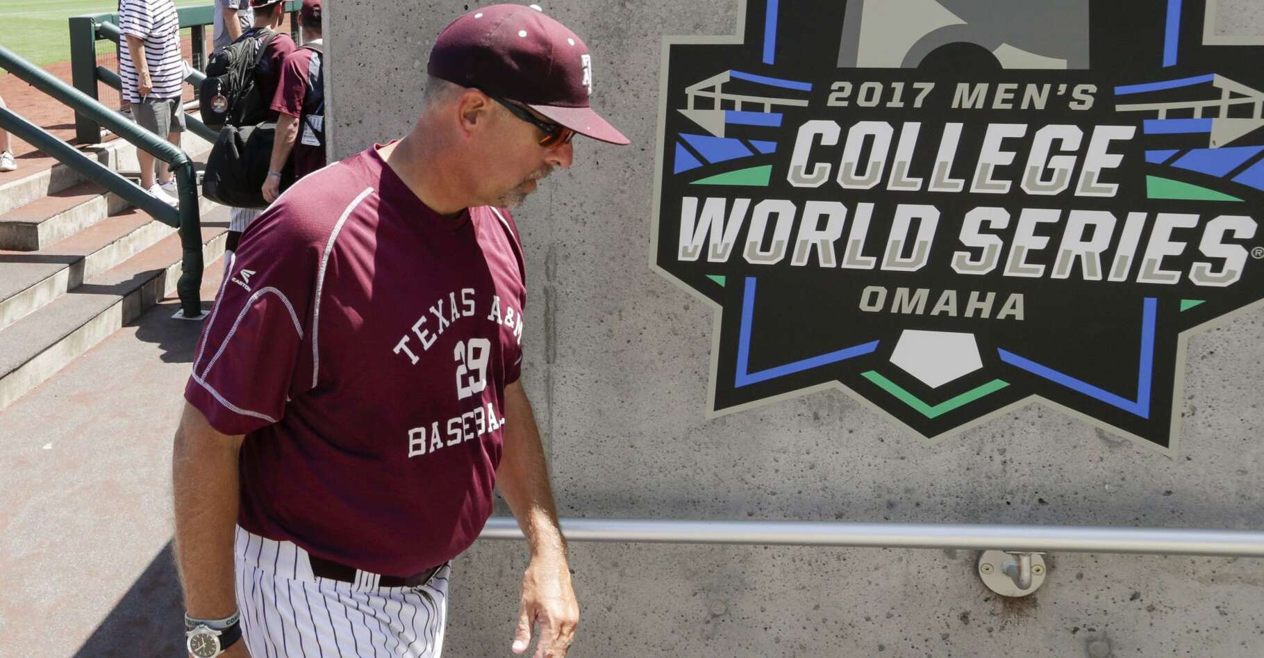 Texas A&M coach Rob Childress walks past a College World Series banner following team practice in Omaha, Neb., Friday, June 16, 2017. Texas A&M plays Louisville in the NCAA baseball College World Series on Sunday. (AP Photo/Nati Harnik)